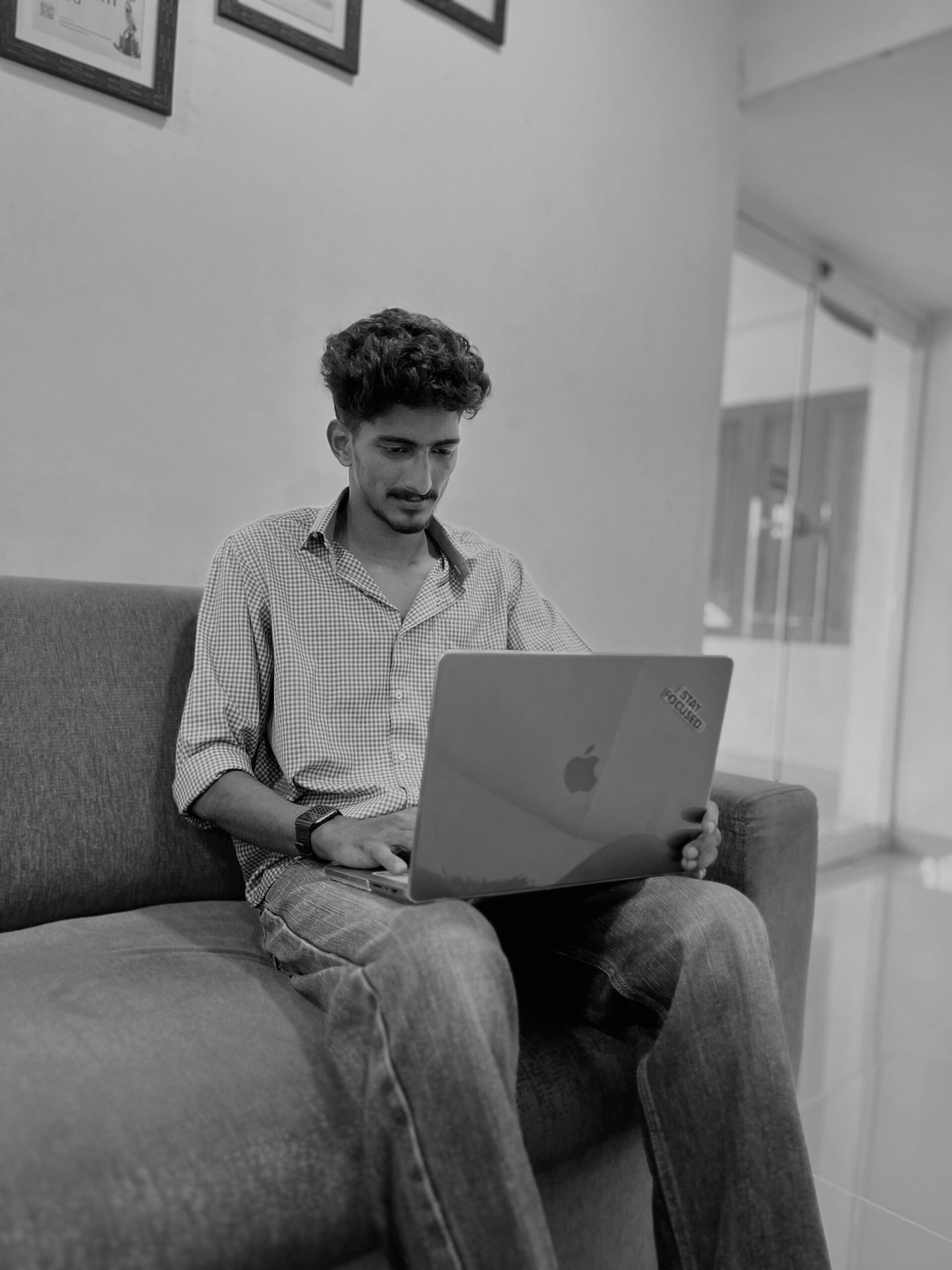 This image shows a person working on a laptop while seated on a couch in a casual setting. If you'd like any specific edits, design ideas, or content suggestions related to the image, let me know!